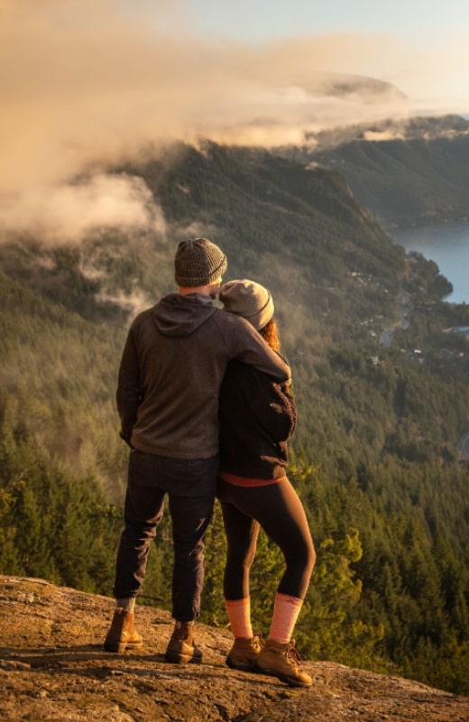 A couple wearing Wigwam hiking socks enjoying the view on top of a ridge